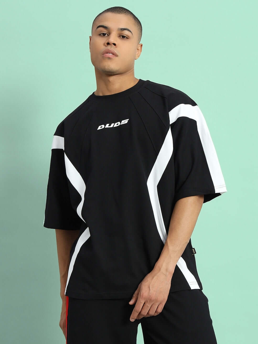 Model wearing WILD FORCE over-sized black and white t-shirt, made of heavy gauge fabric, showcasing modern style and premium cotton comfort.