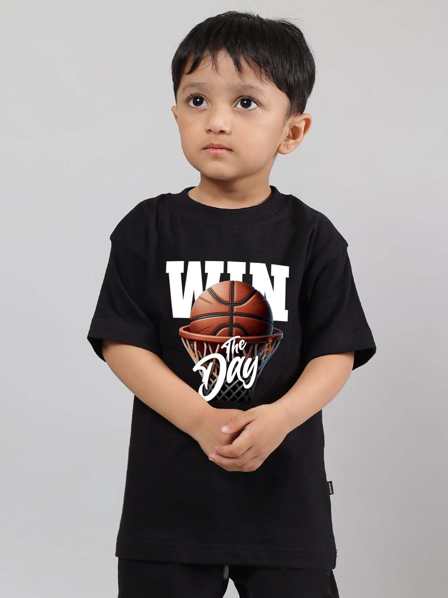 Child wearing a black "WIN the Day" t-shirt for boys and girls, available in customizable sizes, featuring basketball graphic.