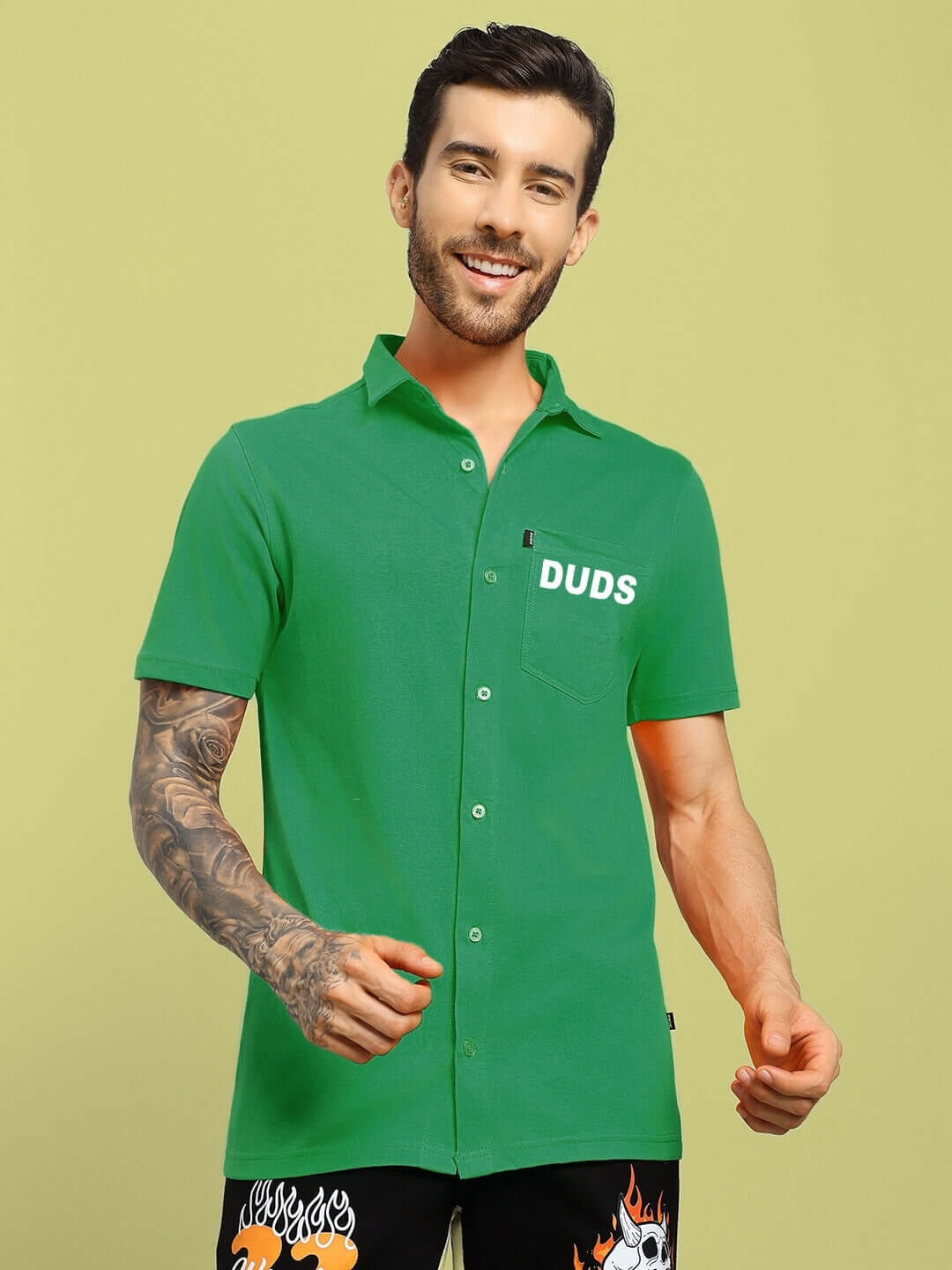 Model wearing green WINGS TEE regular fit shirt by DUDS, showcasing short sleeves and a button-up front.