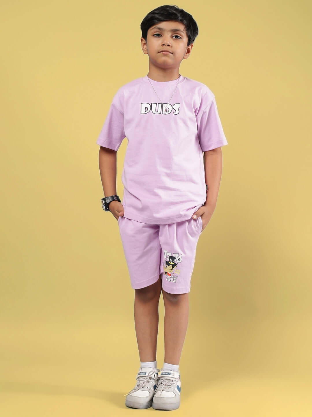 Boy modeling the WOLF PACK CO-ORD FOR BOYS & GIRLS LILAC outfit in lilac color, including a t-shirt and shorts, suitable for kids.