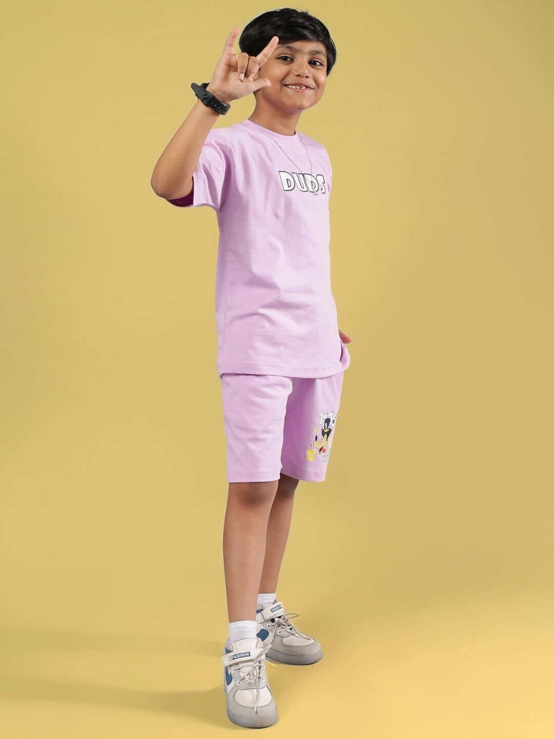 Child wearing WOLF PACK CO-ORD FOR BOYS & GIRLS LILAC with DUDS print on shirt, standing on yellow background.