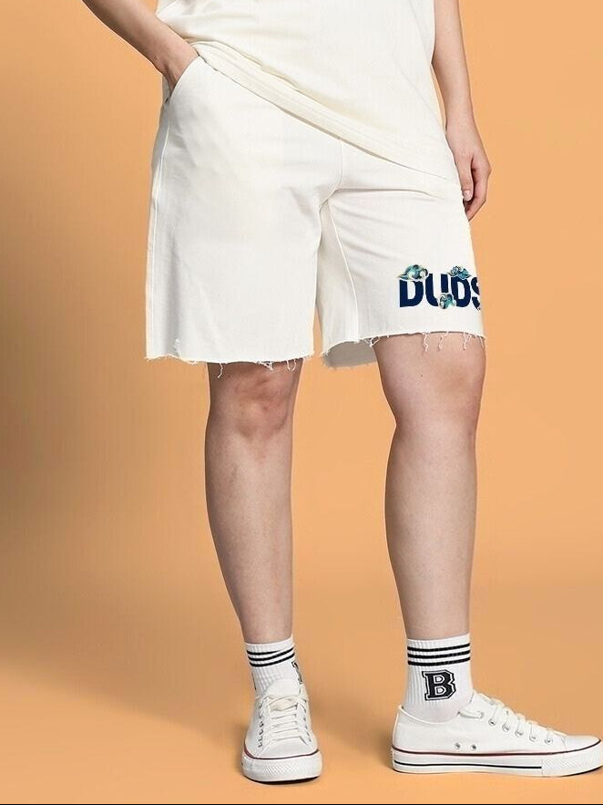 Woman wearing WOMEN CLOUD PRINTED RELAXED FIT SHORTS OFF WHITE, standing against a peach background.