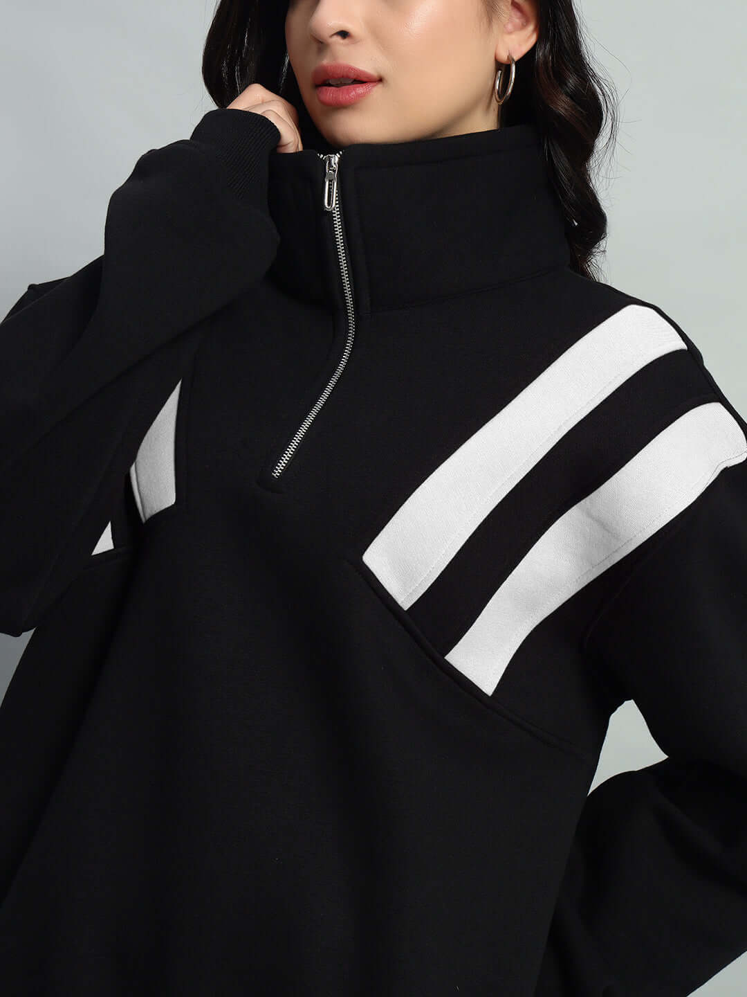 Women's black and white colorblock fleece jacket with crossbar design, high collar, and zip closure.