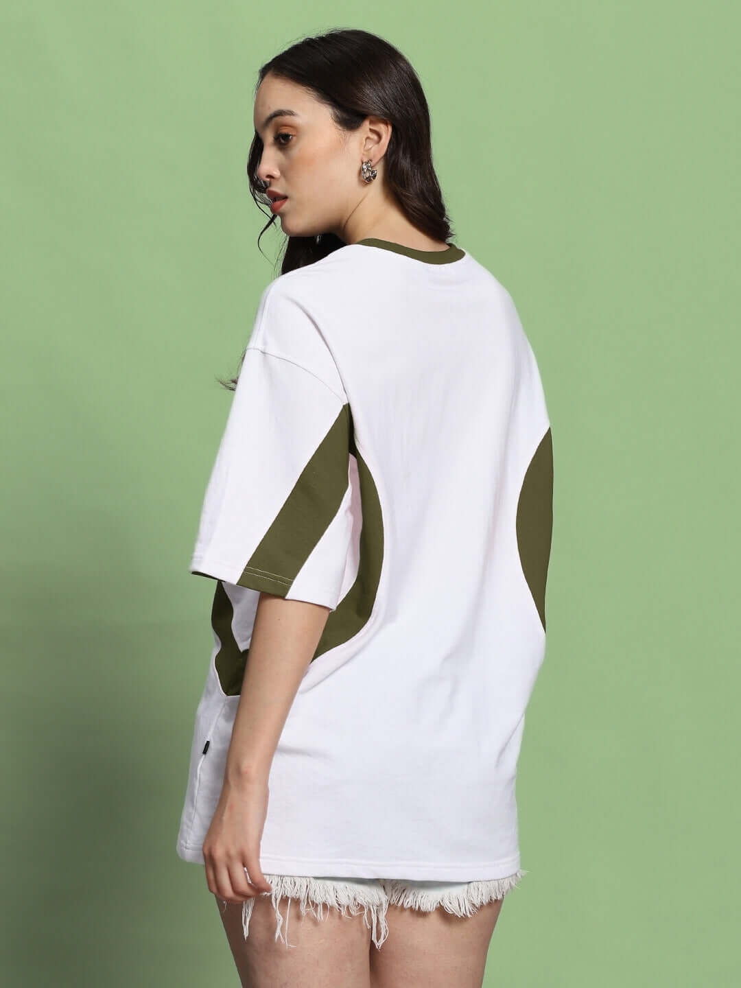 Women's oversized t-shirt in white and olive green with premium cotton blend, back view, styled casually with frayed shorts.