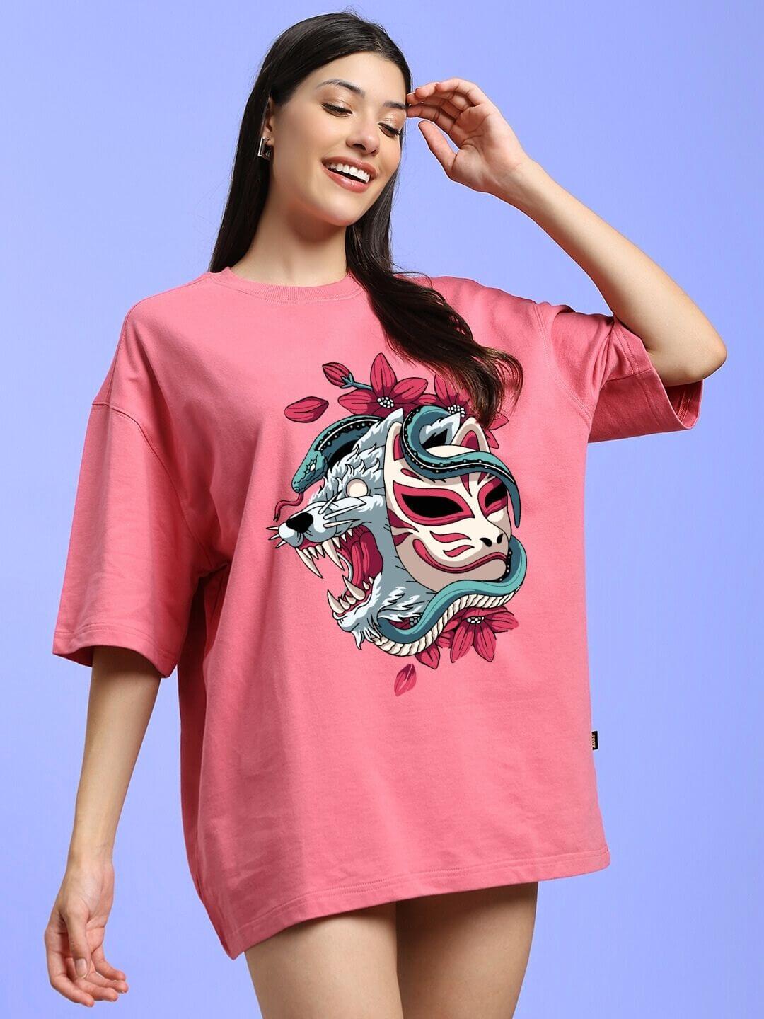 Woman wearing WOMEN KITSUNE WOLF PRINTED OVERSIZED T-SHIRT PINK with wolf design and pastel pink background
