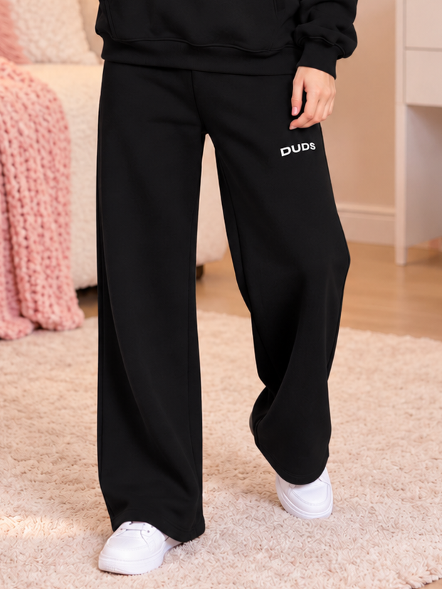 WOMEN MAKE IT HAPPEN COTTON FLEECE JOGGER BLACK with wide-leg fit and DUDS logo, styled with white sneakers