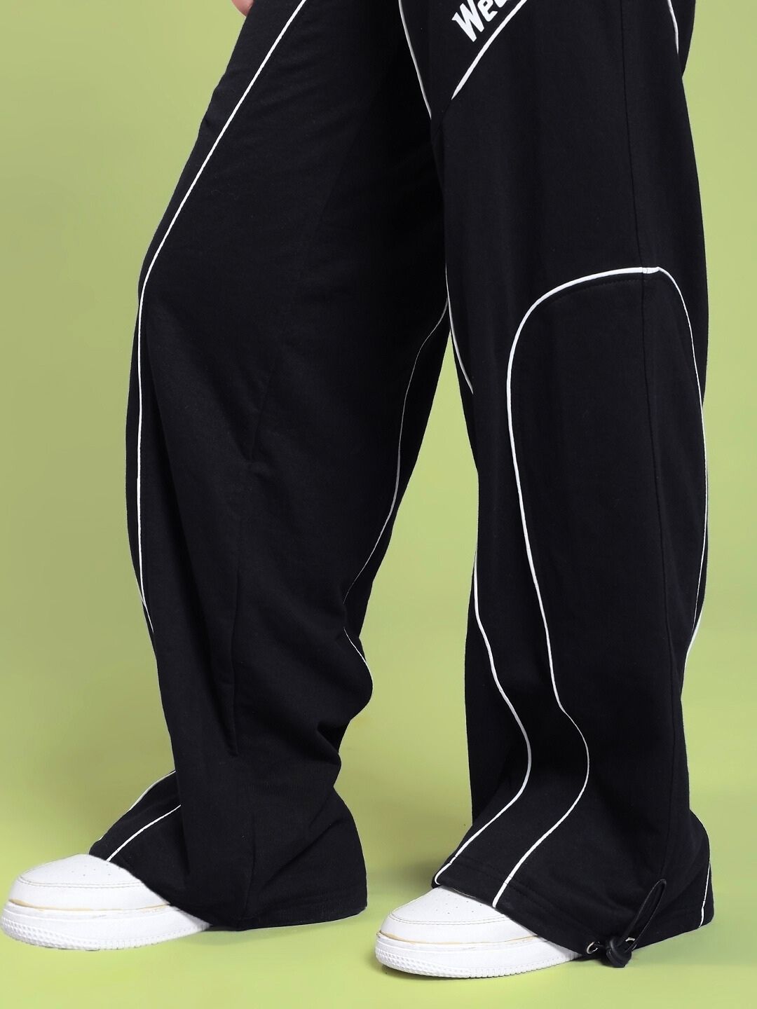 Close-up of WOMEN SIGNATURE PIPING JOGGERS BLACK with contrast piping detail, showcasing sleek street-ready style.