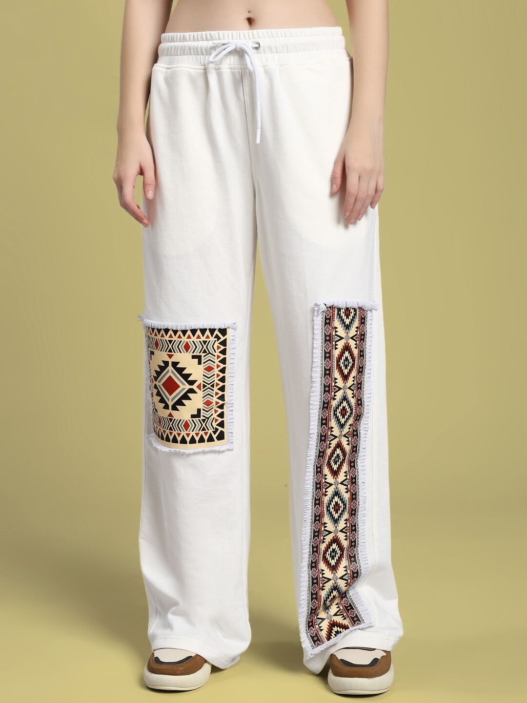 Model wearing WOMEN'S YARA GEOMETRIC PRINT CO-ORD SET OFF-WHITE pants with geometric patterns.