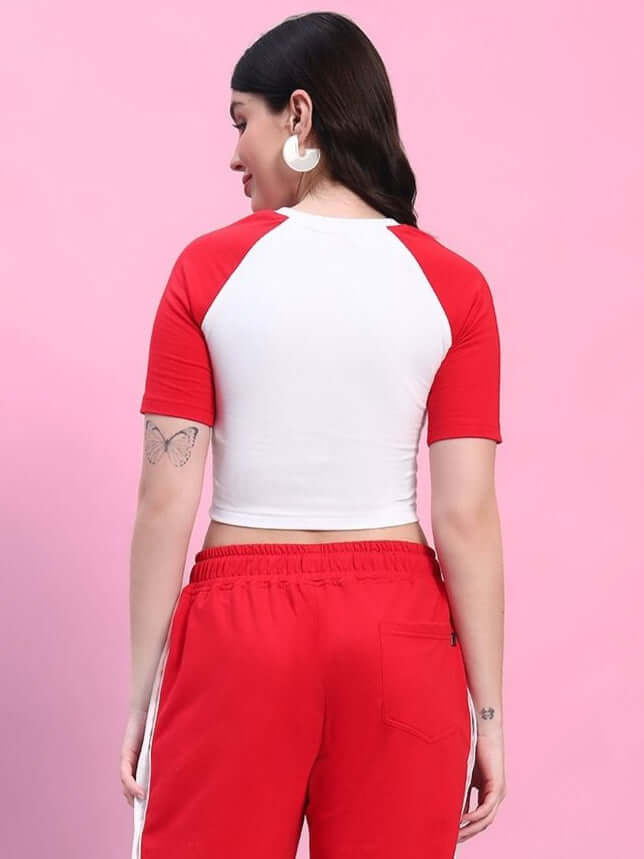 Woman wearing white-red Achorm crop top and red pants, back view.