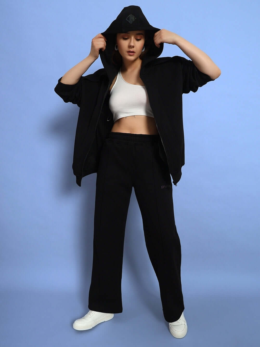 Model wearing WOMEN WD ADMIRE FLEECE CARGO PANT BLACK with white sneakers and black jacket, showcasing streetwear style.