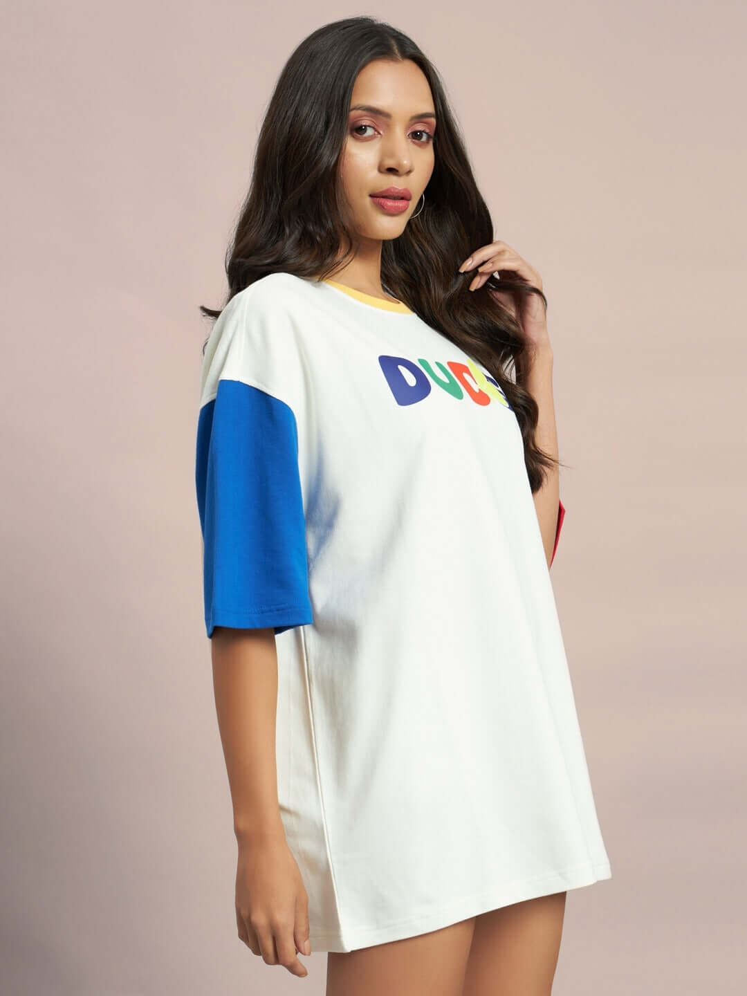 Model wearing women's oversized Adonis color-blocked t-shirt in off-white with blue sleeve, made of premium cotton and elastane.