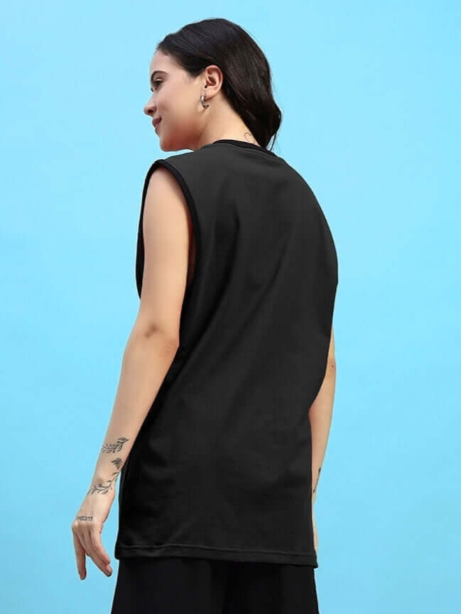 Woman wearing a black Women's Amiga Gym T-shirt from DUDS, showcasing the sleeveless back design against a blue background.