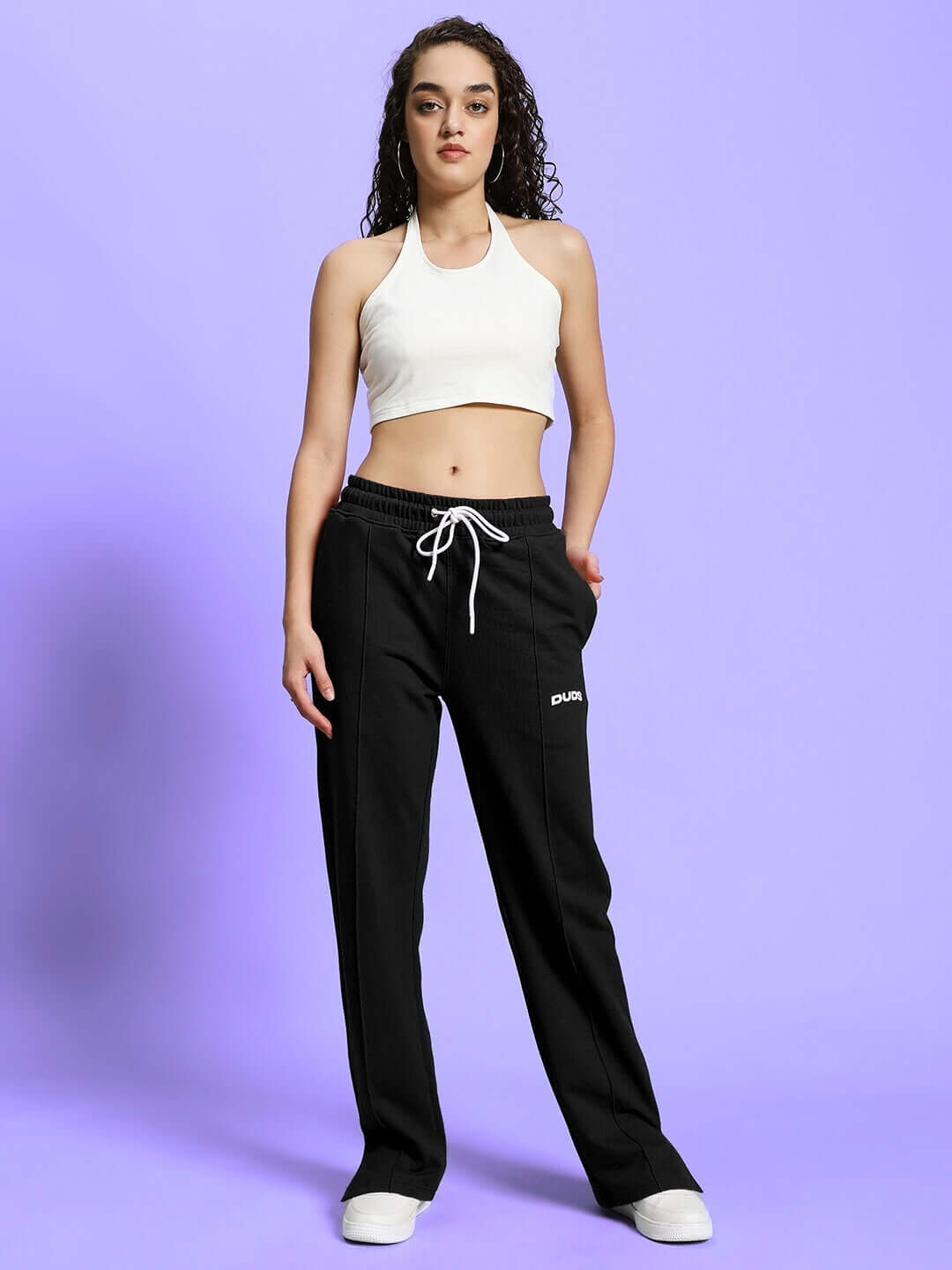 Model wearing WOMEN'S ANISSA CO-ORD SET in black and off-white with relaxed fit joggers and elasticated waistband.