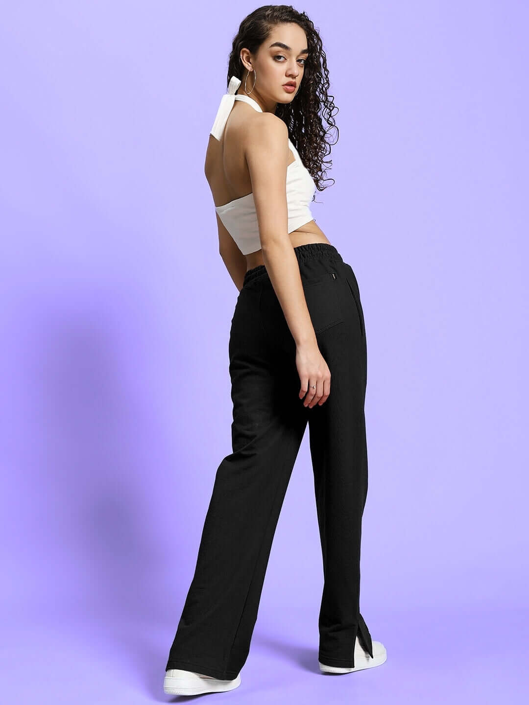 Model wearing Women's Anissa Co-ord Set in black and off-white, featuring relaxed fit joggers and halter top against a lavender background.