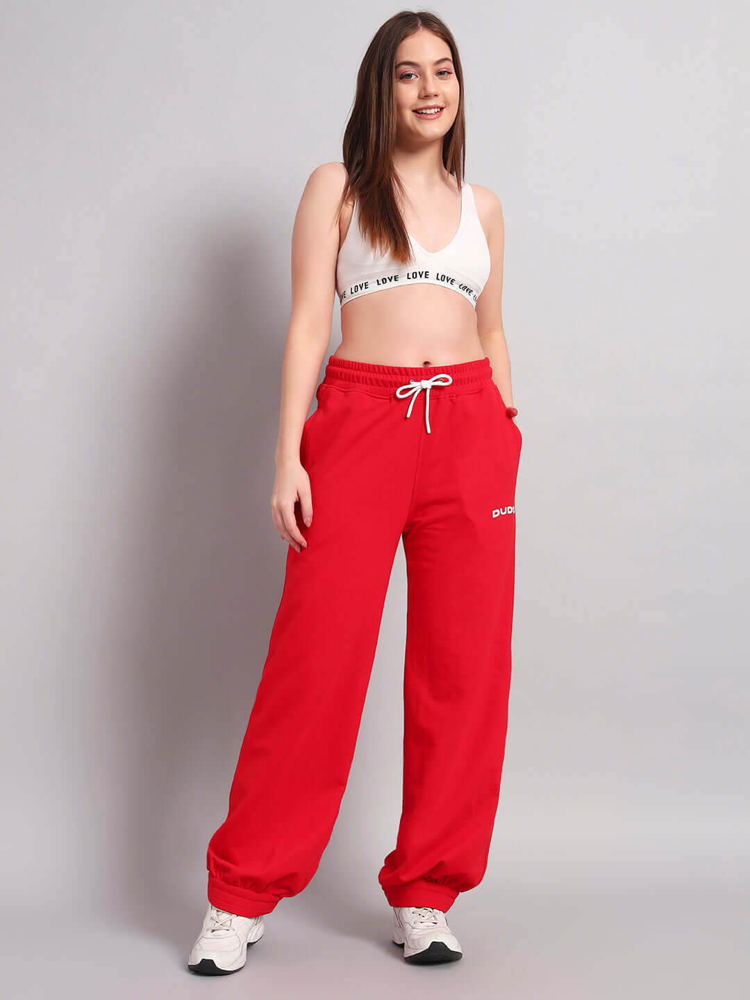Woman wearing WOMENS AUSTRIAN RELAXED-FIT JOGGERS RED standing casually, showcasing sporty and comfortable design.