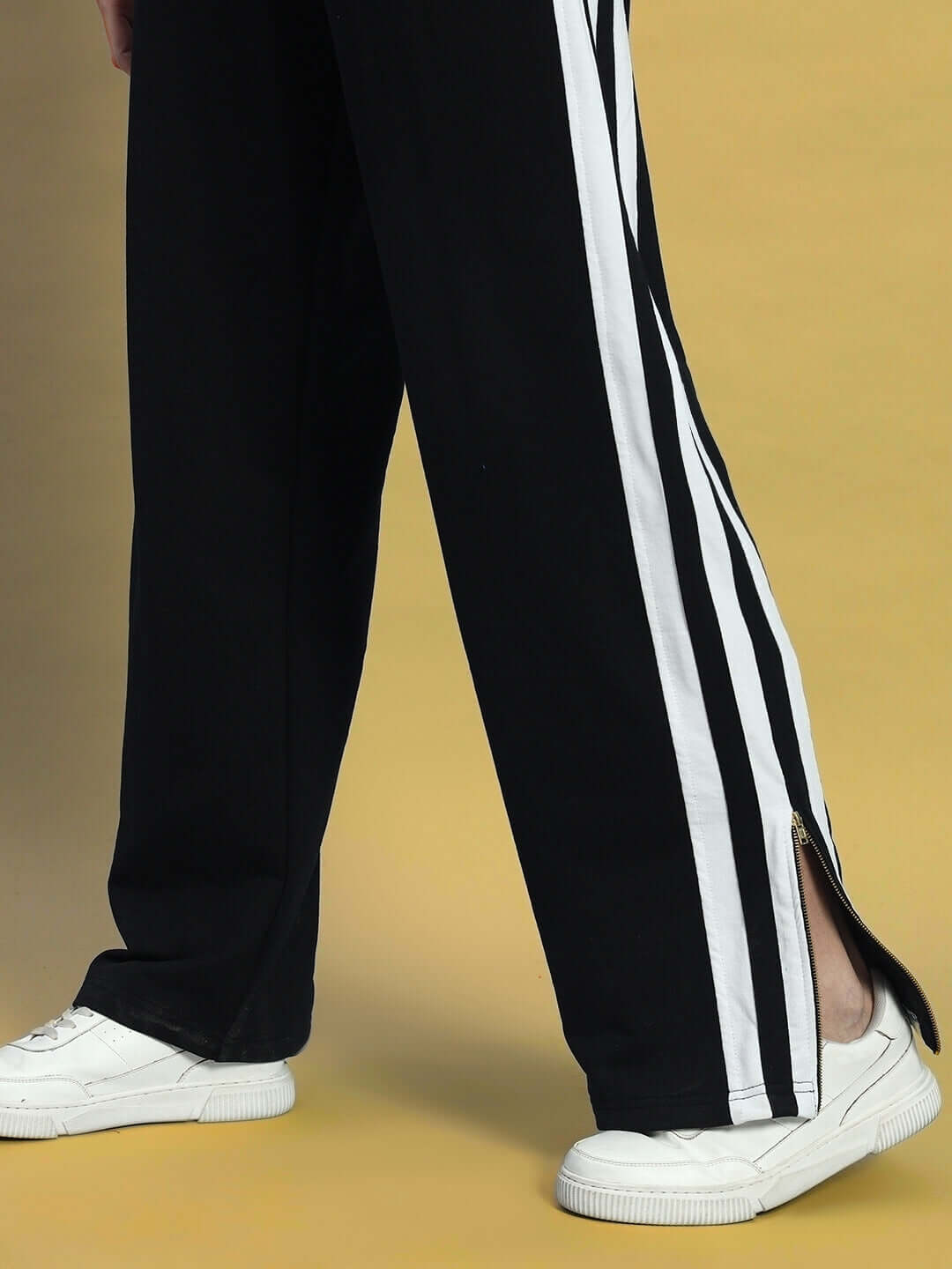 Close-up of Women's Avalon Slit Zipper Joggers in black and white, featuring side zippers and stripe detail.