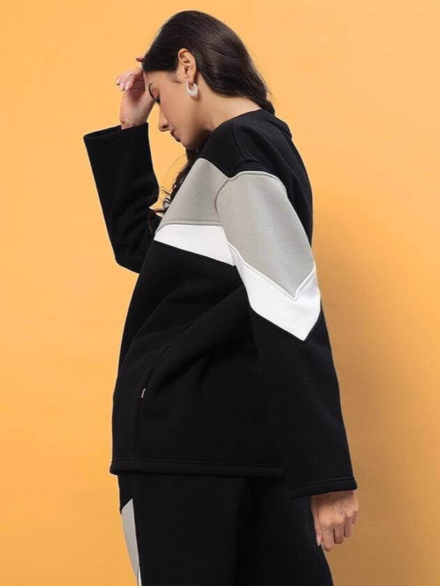 Woman wearing black, grey, and white colorblock fleece co-ord set, featuring aviator style and long sleeves.