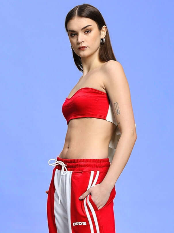 Model wearing Women's Azora Bandeau Top in red, crafted from premium heavy gauge cotton fabric, posing against a blue background for a fashion shoot.