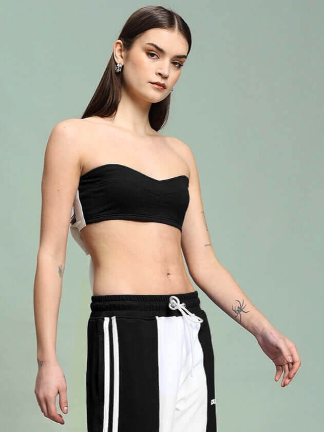 Model wearing WOMEN'S AZORA BANDEAU TOP in black, made of premium heavy gauge 100% cotton, styled with sporty trousers.