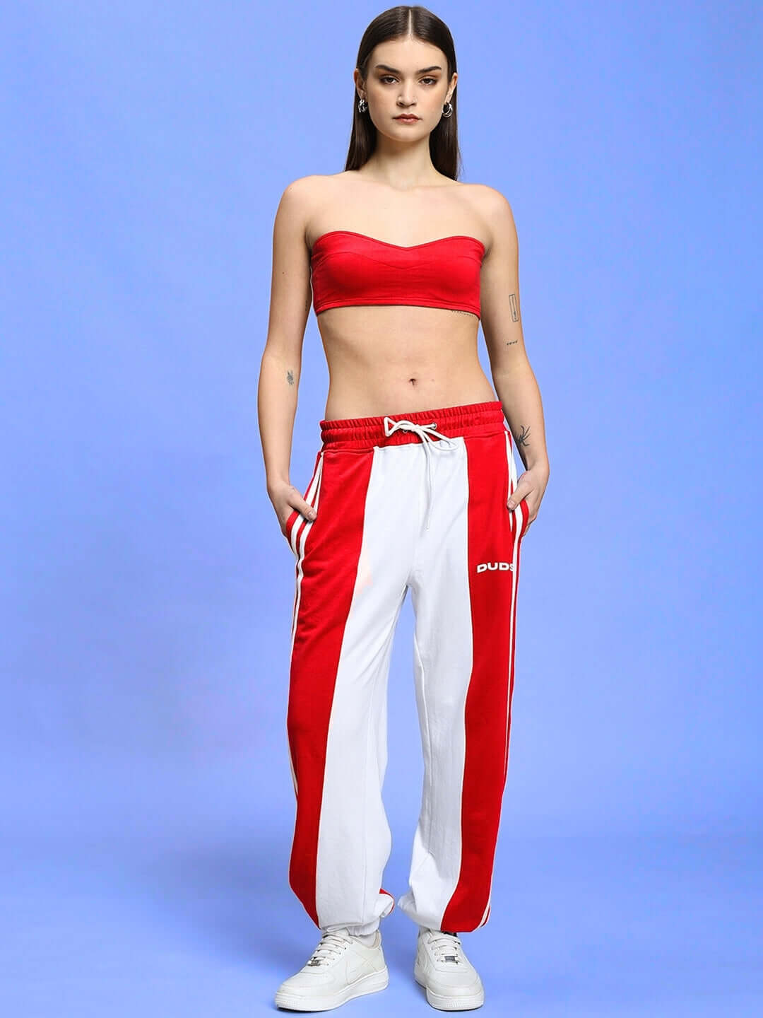 Woman in red-white Azora co-ord set featuring relaxed fit joggers with elasticated waistband and drawstring on a blue background.