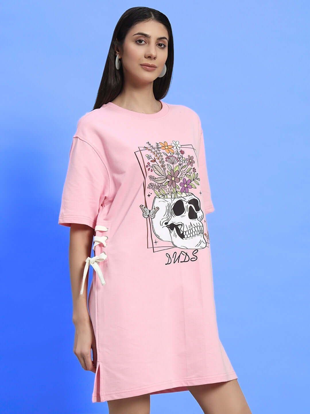 Woman wearing baby pink sugar skull dress made from premium cotton fabric. Features floral skull design. Perfect for casual wear.