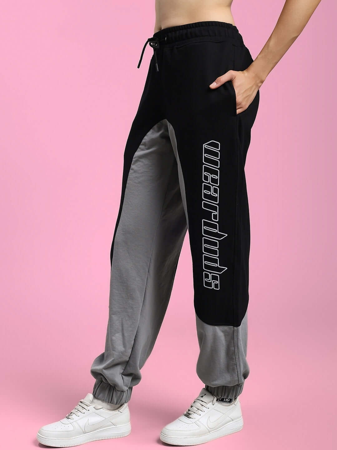Black grey women's relaxed fit joggers with customizable fit option, made by DUDS. Side view showing design and logo detail.