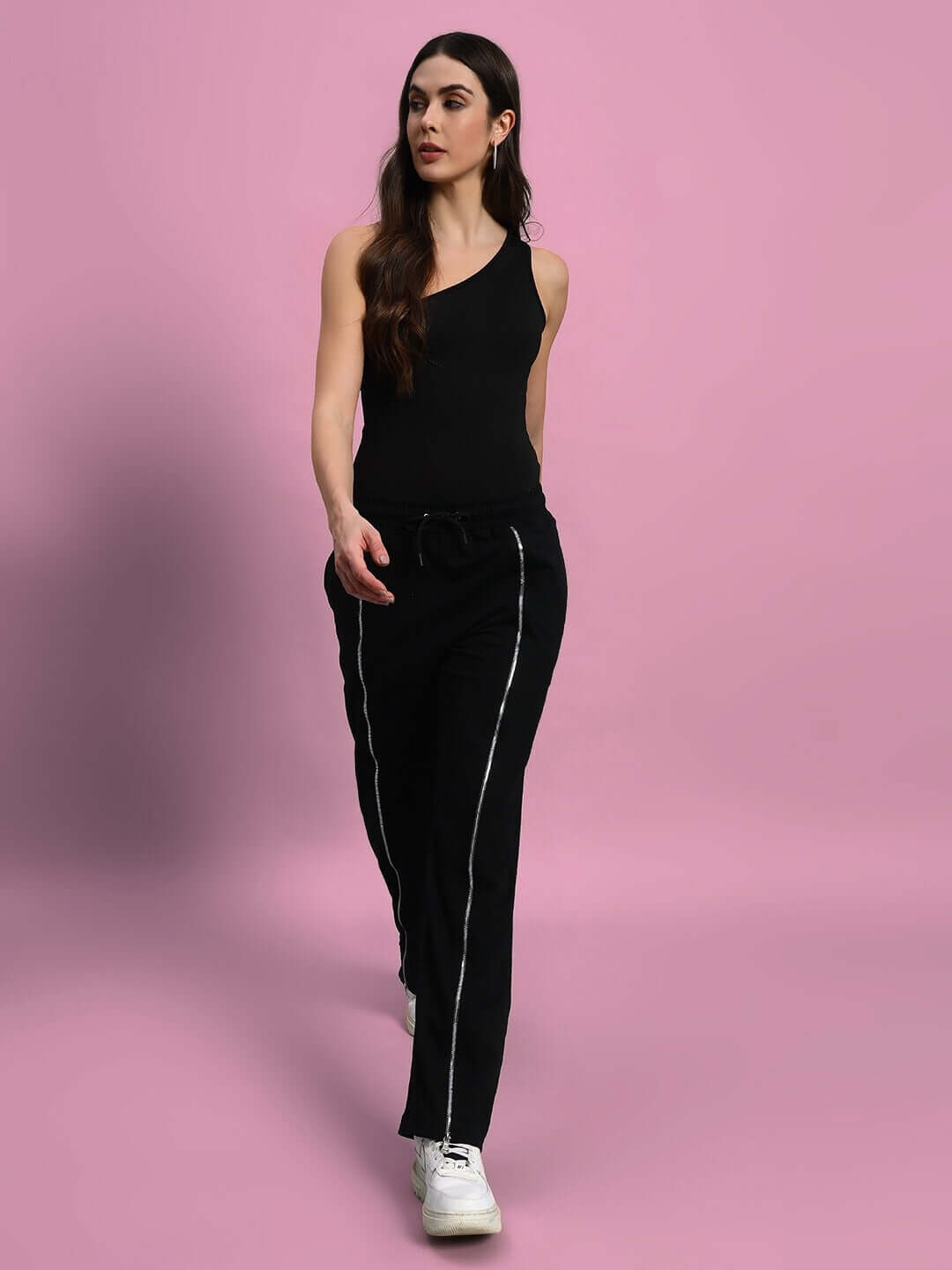 Woman wearing black Brazo front open zipper joggers, showcasing stylish casual wear from DUDS, set against a pink background.