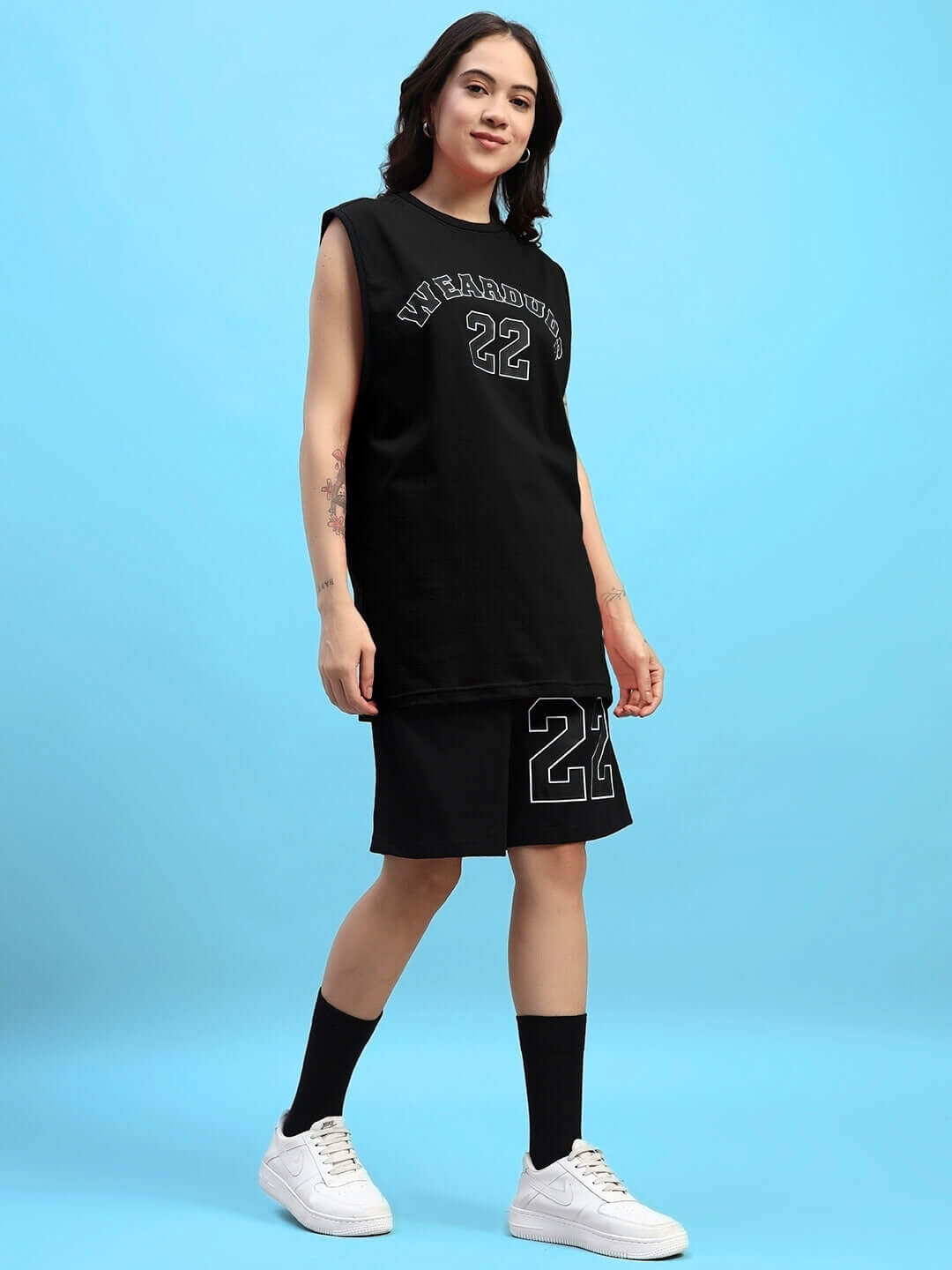 Model wearing Women's Amiga Gym Co-ord Set in black with printed number 22, featuring a sleeveless top and shorts, ideal for workouts.