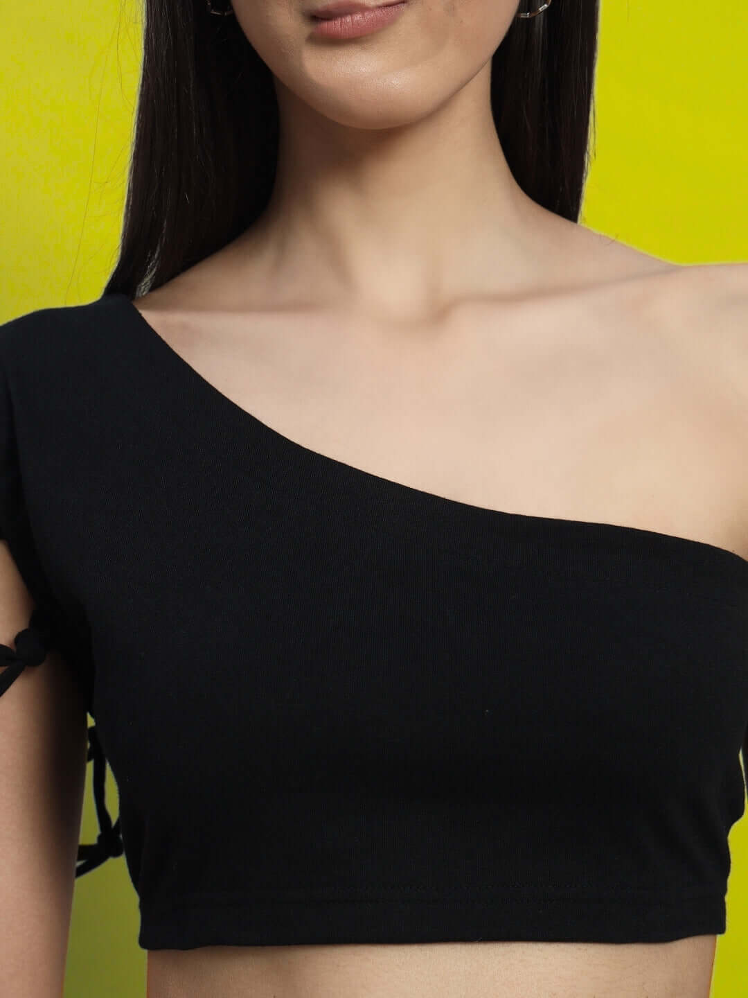 Black women's macrame crop top made from premium cotton Lycra fabric, showcasing one-shoulder design against a yellow background.