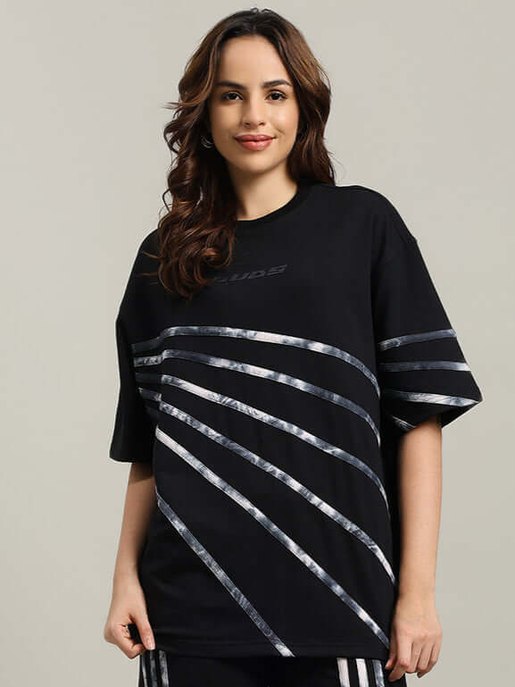 WOMEN'S FLICKER DESIGNER OVERSIZED T-SHIRT BLACK with premium cotton and elastane blend, showcased by a smiling model, bio-washed fabric.