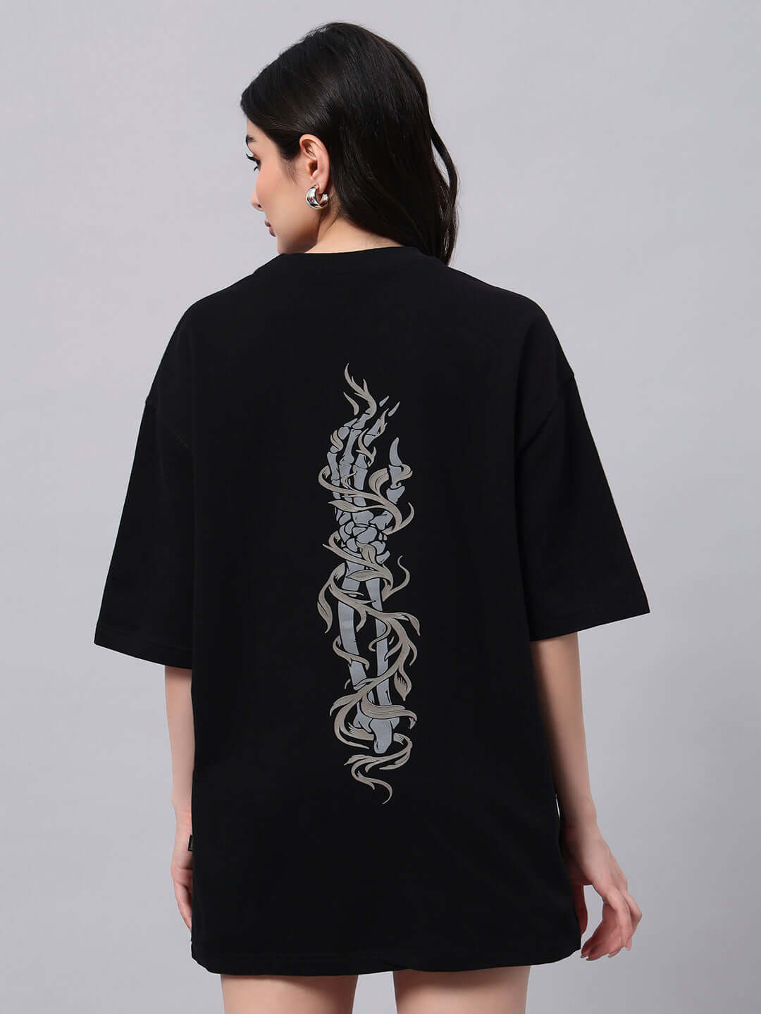 Model wearing women's black oversized T-shirt with intricate back design, made of premium cotton blend, by Color By Colours.