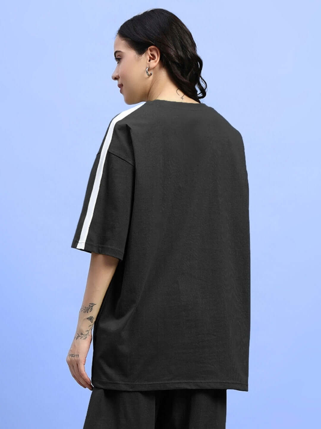 Back view of women's black oversized t-shirt made from premium French terry cotton with white stripe detail