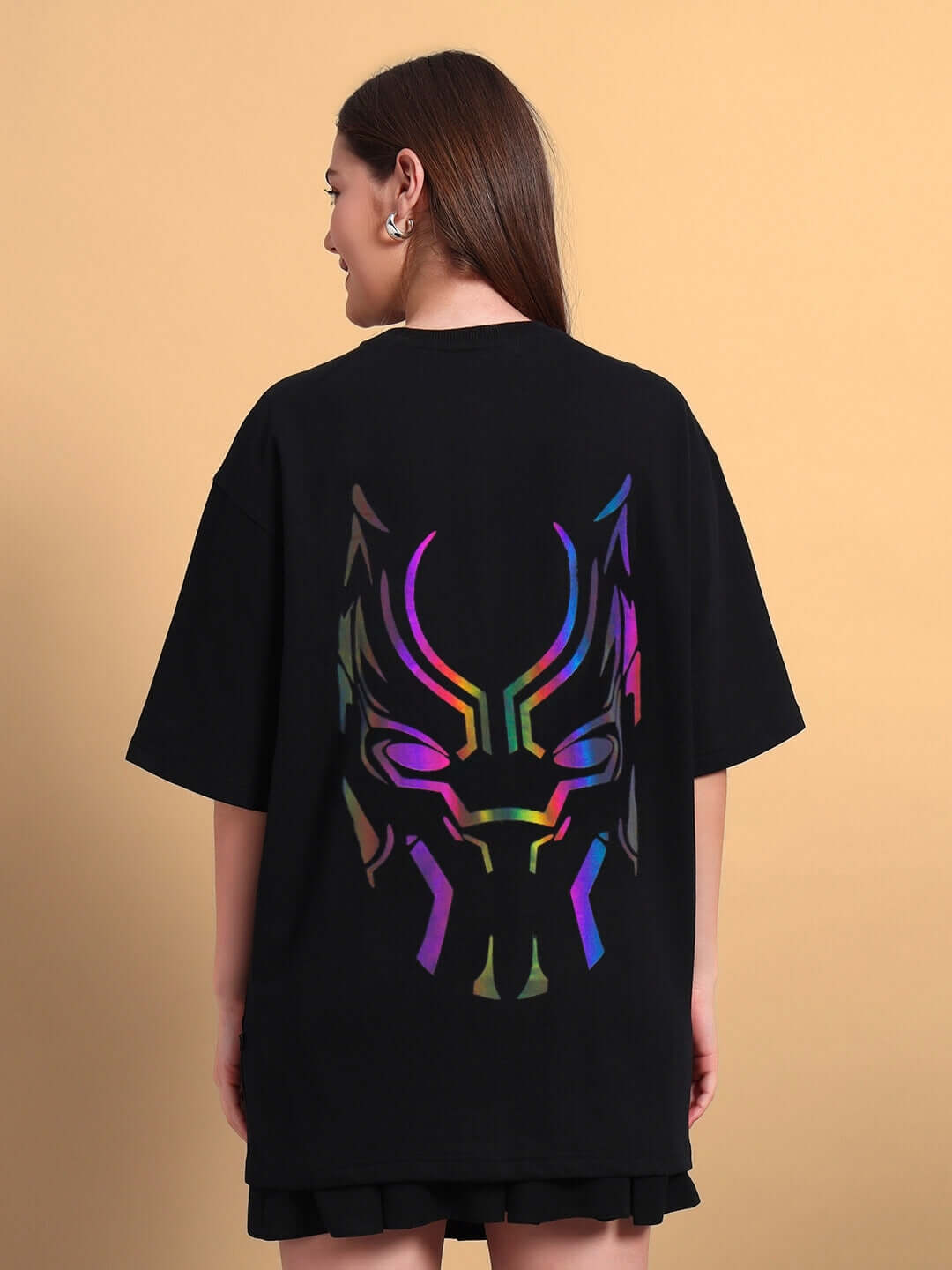 Woman wearing a Women's Black Panther Reflector Over-Sized T-Shirt in black with a colorful panther design on the back.