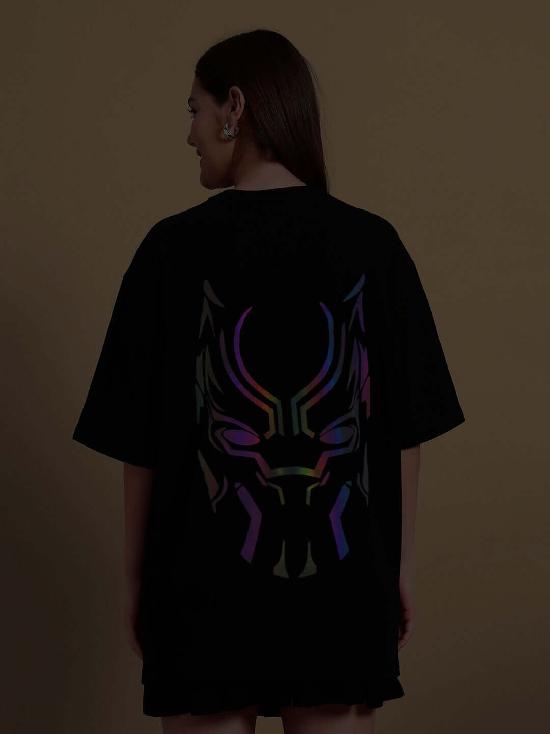 Woman wearing oversized black T-shirt featuring Black Panther design with reflective accents on the back, made of premium cotton fabric.