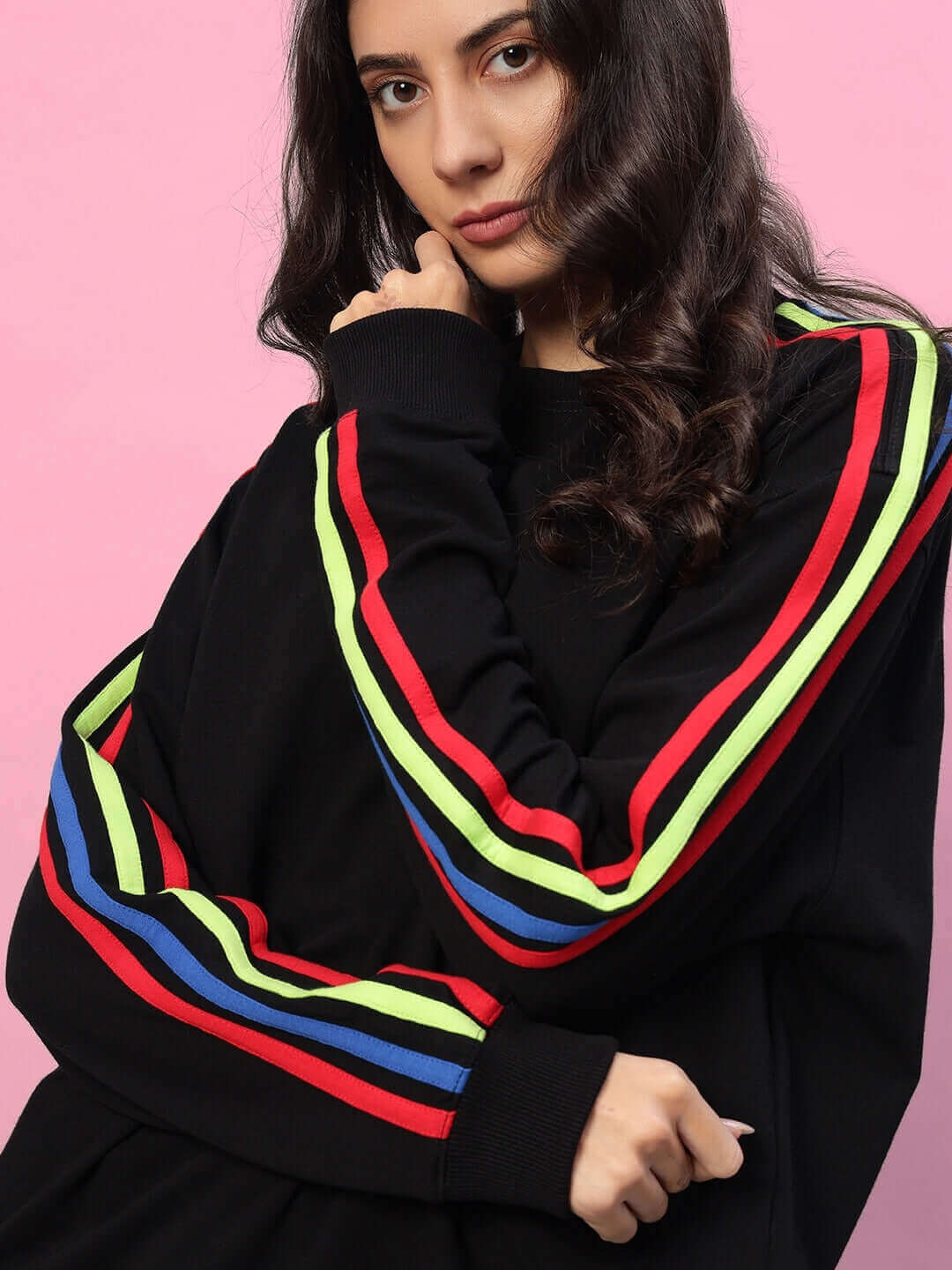 Model wearing women's rainbow oversized co-ord set in black with colorful stripe detailing on sleeves, showcasing a relaxed fit.
