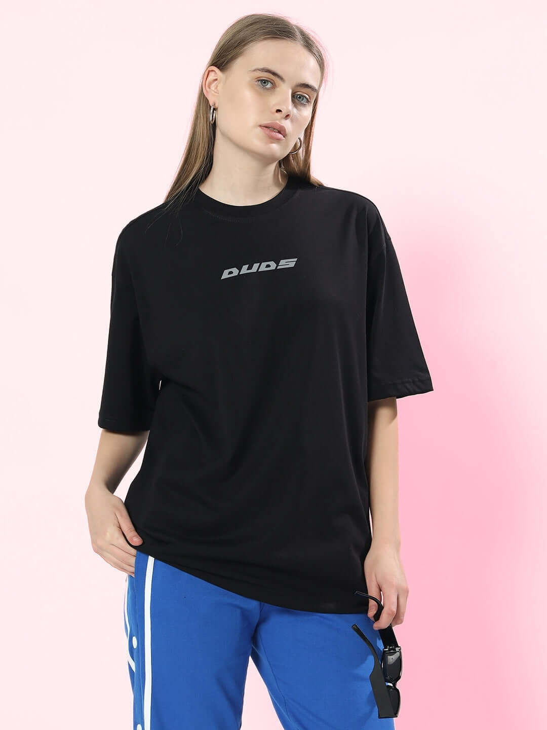 Model wearing women's black oversized T-shirt from Color By, made from premium cotton blend, featuring front logo design.