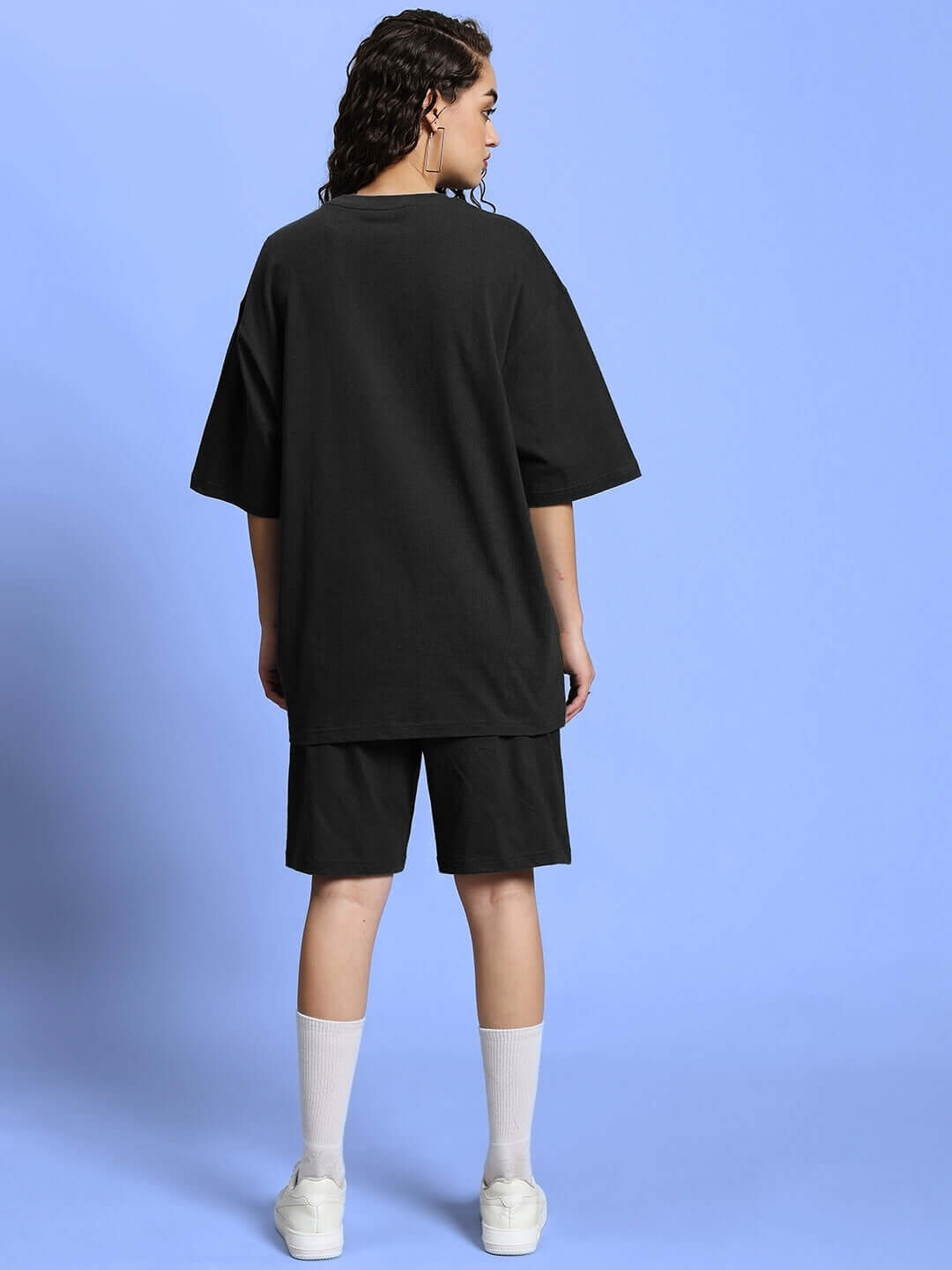 Back view of model wearing WOMEN'S OUTLOOK SUMMER CO-ORD SHORTS SET BLACK against blue background.