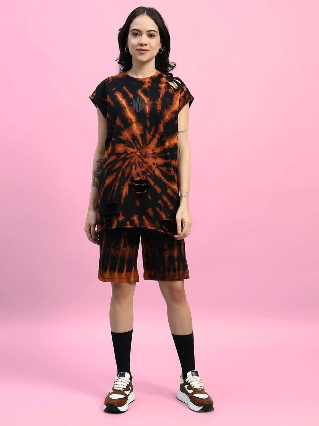 Woman wearing WOMEN'S MUSCLE TEE RIPPED TIE-DYE CO-ORD SET BLACK against pink background
