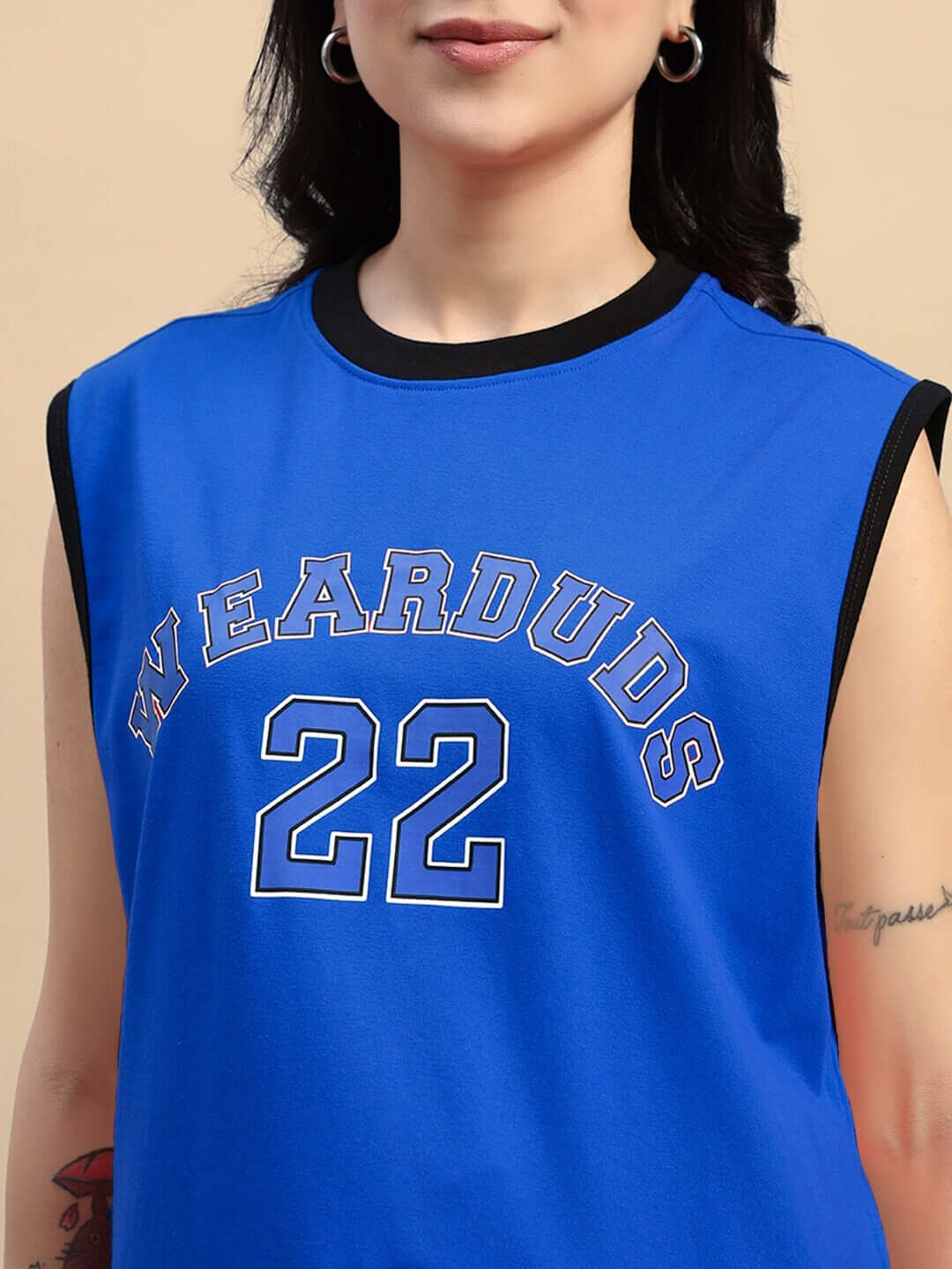 Blue athletic top with 'WEARDUDS 22' printed, worn by a woman with hoop earrings.