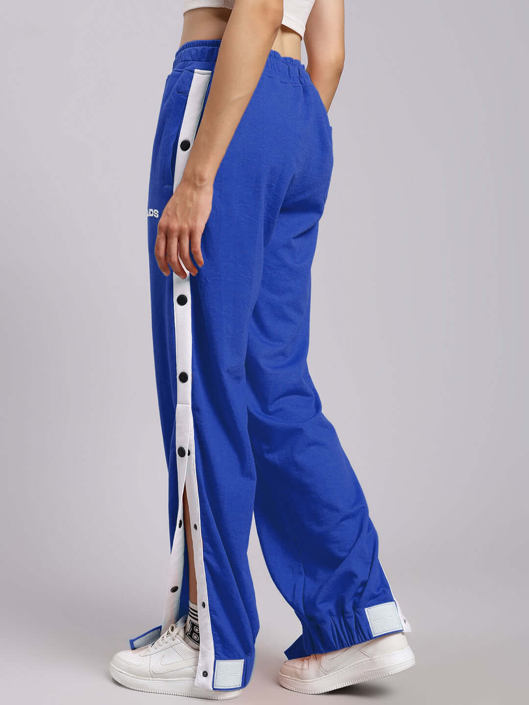 Side view of women's blue relaxed fit joggers with customizable size options, featuring buttoned trim and comfortable elastic waistband.
