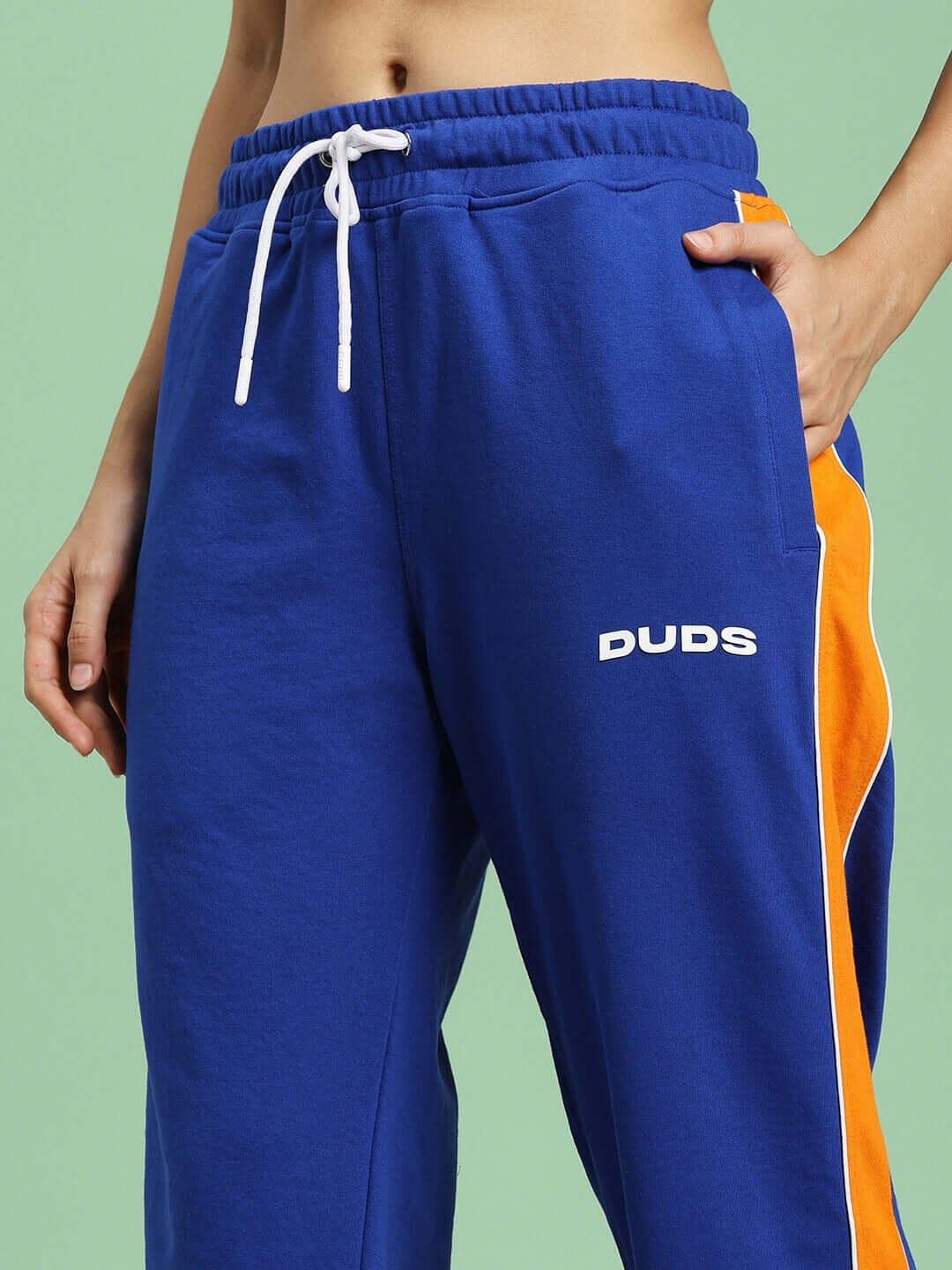 Model wearing WOMEN'S SANFORD STRIPE JOGGERS BLUE with orange stripe detail by DUDS, showcasing custom fit options.