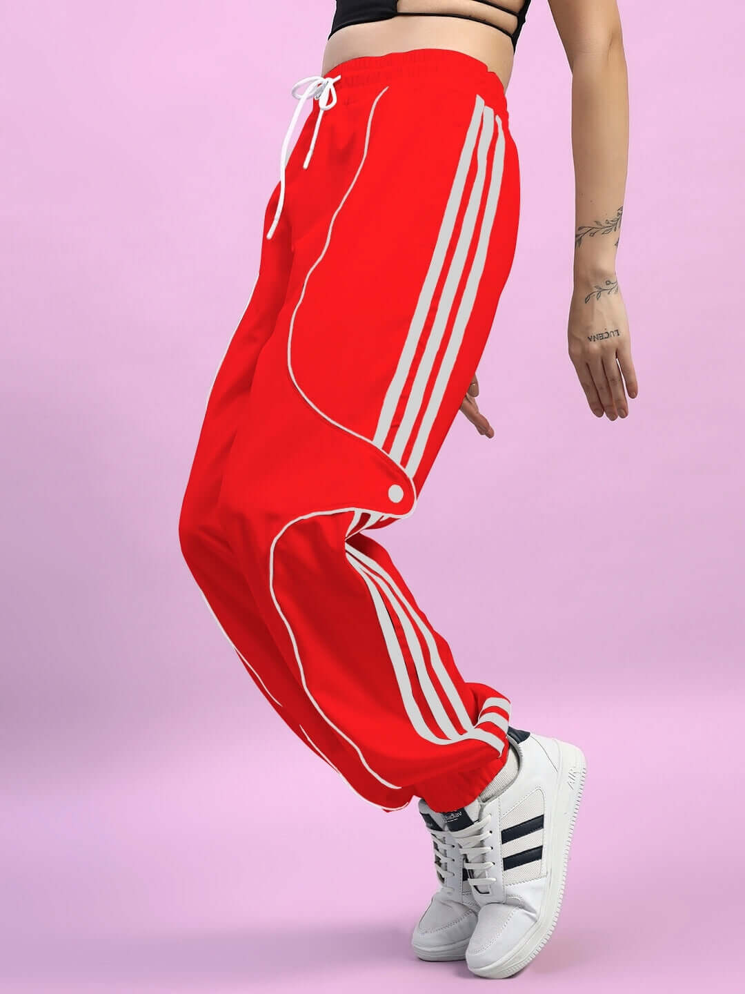 Red women's Bolson striped relaxed-fit joggers with white sneakers on a pink background
