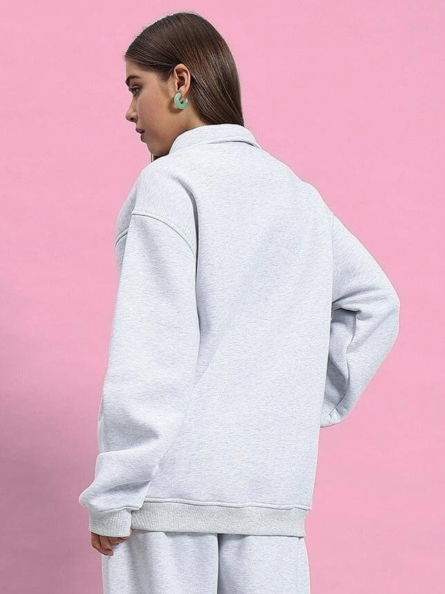 Side view of woman wearing Women's Bona-Fide Sweatshirt in melange grey against pink background, showcasing relaxed fit and style.