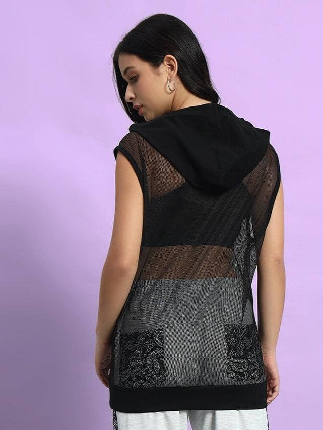 Rear view of a woman wearing a black Boogie Mesh Sleeveless Hoodie Vest, showcasing stylish fashion with a sheer and patterned back design.
