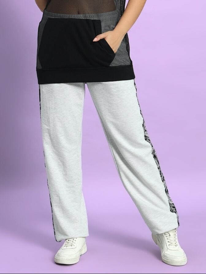 Woman wearing Women's Boogie Relaxed Fit Joggers in Melange Grey with side pockets and casual white sneakers.