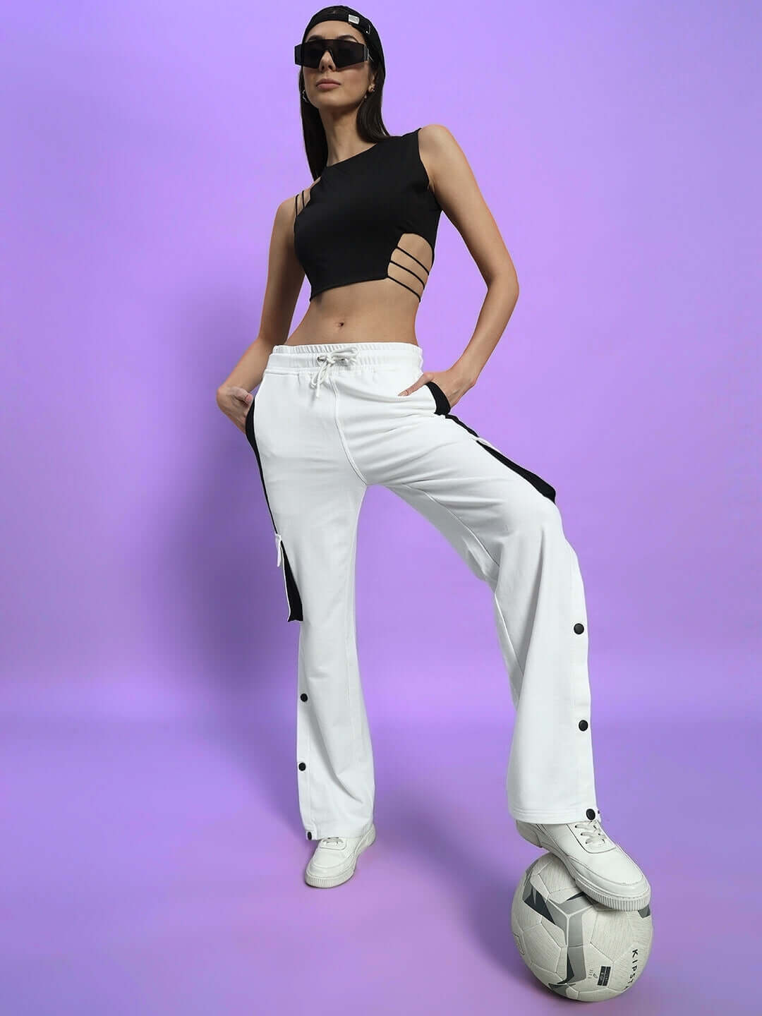 Model wearing WOMEN'S BRACKET CARGO PANT WHITE BLACK HIGHLIGHTER with sporty top, showcasing stylish utility design with neon accents.