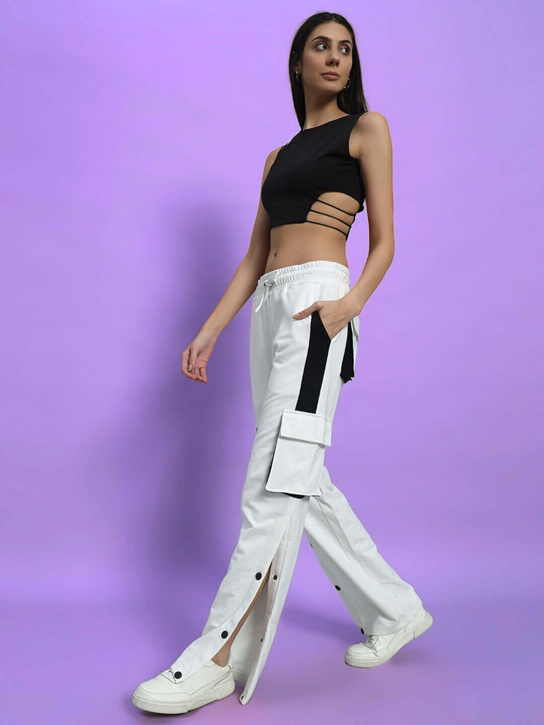 Model wearing Women's Bracket Cargo Pant in White Black Highlighter with neon accents, showcasing style and utility on a purple background.