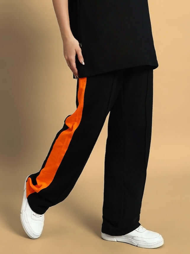 Women's black joggers with orange side contrast by DUDS, featuring custom fit options. Made to order with 7-10 day shipping.