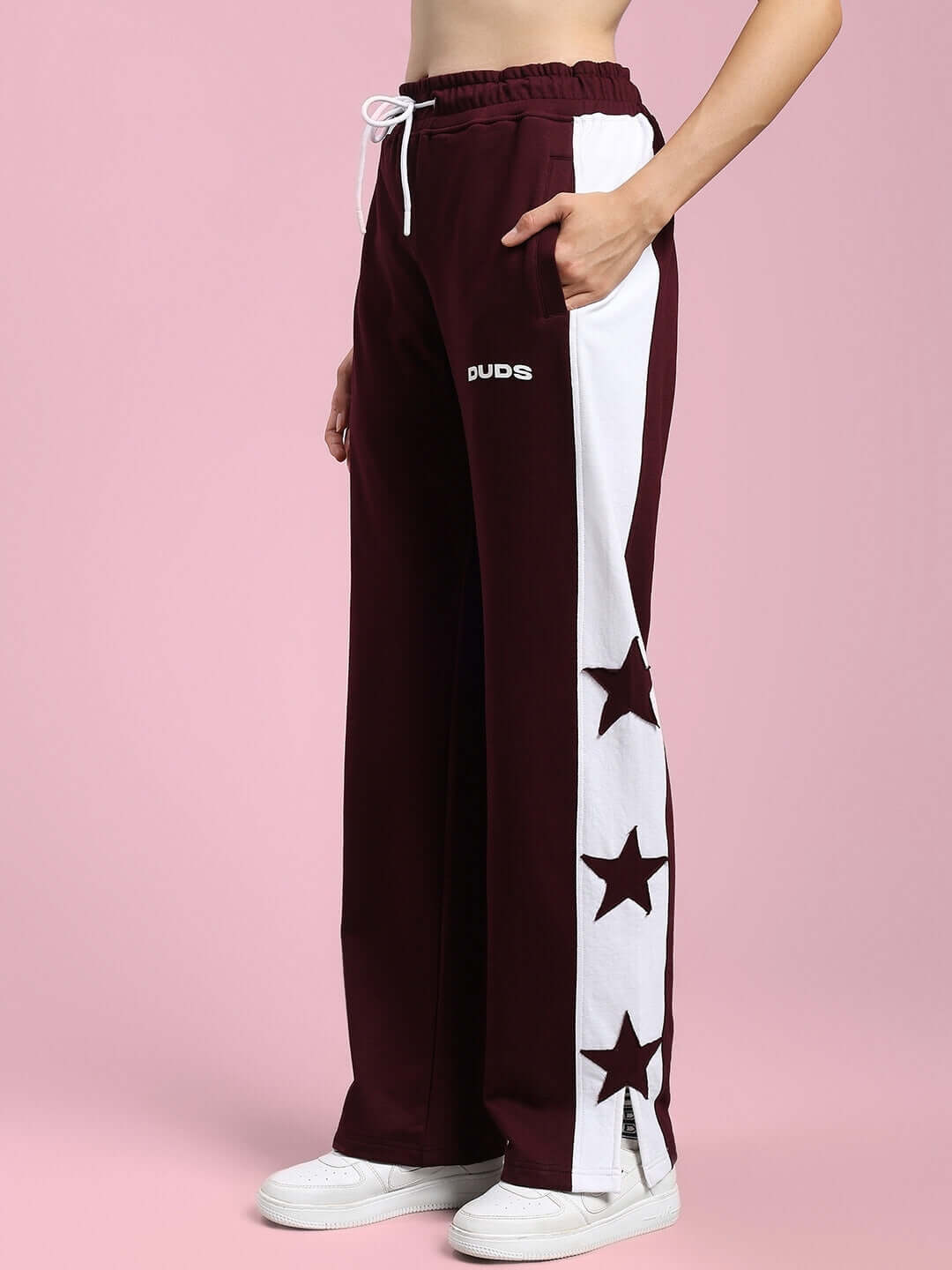 Women's maroon joggers with white side panel and star design by DUDS, showing relaxed fit and custom size options available.