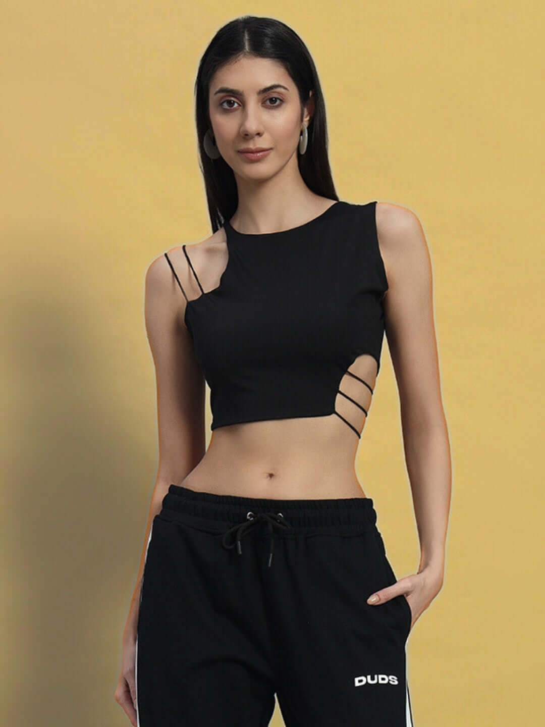 Woman wearing a black crop-top made of premium heavy gauge fabric with side strap details.